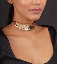 The hammered gold metal choker is modern and chic. The wide statement choker by Studio Metallurgy has a boho tribal inspiration. The thick choker is adjustable using a string. The metal choker is in a gold colour and versatile- it can be worn with a variety of outfits. The choker is handmade with a textured finish and gold plated. Style it with dressy tops and dresses- ruffles, strappy, or off-shoulder. Wear it with your collared shirts or even with draped feminine dresses. For a grungy look, we Chic Gold Jewelry For Festival, Gold Metal Festival Choker, Bohemian Gold Metal Choker, Gold-tone Metal Choker For Party, Gold-tone Choker Jewelry For Parties, Gold-tone Choker For Party, Elegant Gold Choker For Festivals, Hammered Metal Choker Necklaces, Metal Hammered Choker Necklace