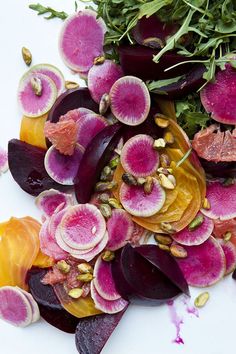 beets and other vegetables are arranged on a white surface