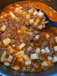 a bowl filled with meat and potatoes on top of a stove