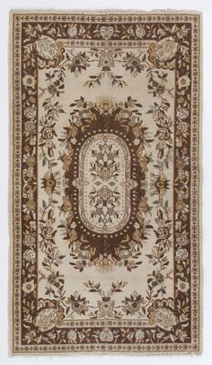 an area rug with brown and white designs on the center, surrounded by gold trimmings