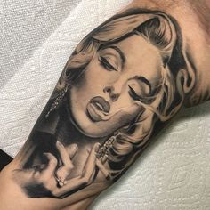 a man's arm with a black and white tattoo of a woman holding a baby