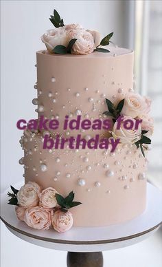 a pink cake with white flowers on top and the words cake ideas for birthday above it