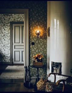 the hallway is decorated with wallpaper and flowers in vases next to an open door