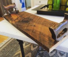 a wooden cutting board sitting on top of a table next to green glass vases