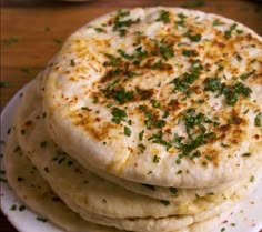 three flat breads stacked on top of each other with herbs sprinkled on them