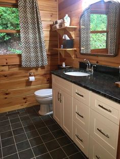 a bathroom with wood walls and tile flooring