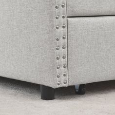 the back end of a couch with studded buttons on it's armrests