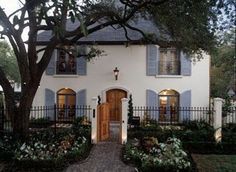 a white house with blue shutters and a cross on the front door at night