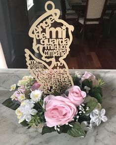 a bouquet of flowers sitting on top of a marble counter next to a wooden sign