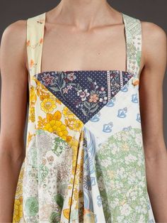 the back of a woman's dress with flowers on it and an apron over her shoulder