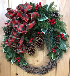 a christmas wreath with pine cones and holly