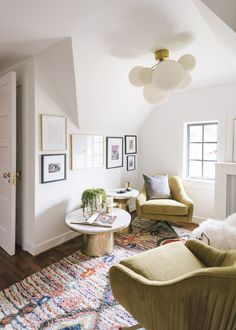 a living room filled with furniture and pictures on the wall