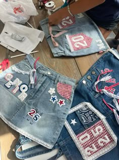 two pairs of jean shorts with patches and stars on them are being sewn together