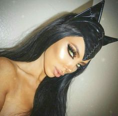 a woman with long black hair wearing a cat ears headpiece and green eyeshade