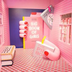 a room with pink walls and furniture in the corner, including a big boom of girls sign on the wall