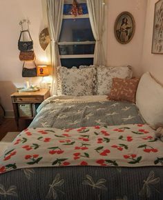 a bed sitting in a bedroom under a window next to a table with a lamp on it