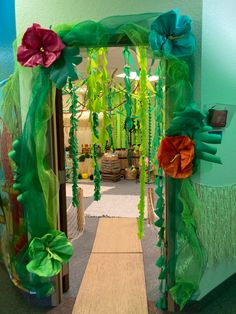 a hallway decorated in green and orange with flowers on the door way to another room