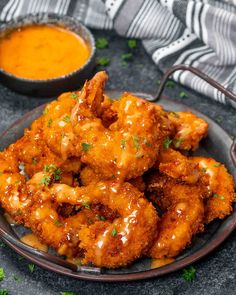 a plate filled with fried chicken next to a bowl of dipping sauce