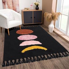 a black rug with different colored circles on it in a room next to a white chair