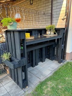 an outdoor table and bench made out of pallet wood with plants on the top