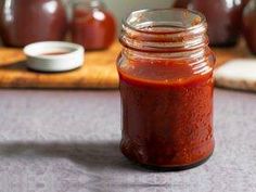 a jar filled with red sauce sitting on top of a table