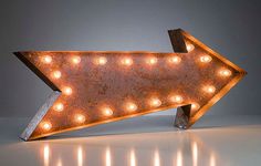 an arrow shaped light up sign with lights on it