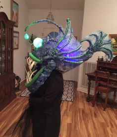 a person wearing a blue and green mask with an octopus on it's head