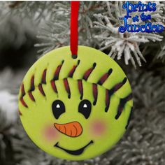 a softball ornament hanging from a christmas tree