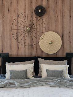 a bed that has some pillows on top of it and two circles above the headboard