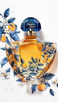 a bottle of perfume sitting on top of a white table next to blue and yellow flowers