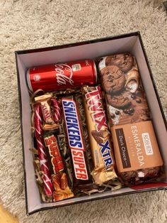 an open box filled with assorted chocolates and candy bar flavors on carpeted floor