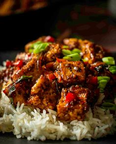 a close up of food on a plate with rice and broccoli in the background