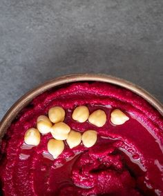 a bowl filled with beet and almonds on top of a gray countertop