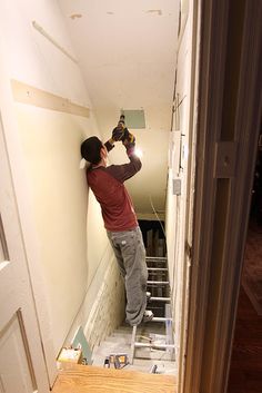 a man is painting the walls in his house