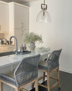 two wicker bar stools sit at an island in the kitchen