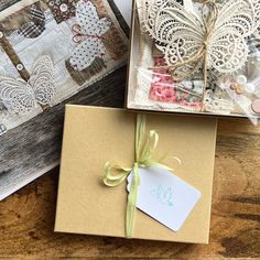 two boxes with tags tied to them sitting next to each other on top of a wooden table