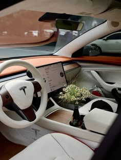 the interior of a modern car with dashboard and steering wheel, flowers in vase on table