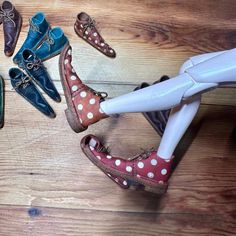 several pairs of shoes are sitting on a wooden floor next to a hair dryer