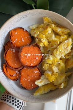 a white bowl filled with eggs and other food on top of a table next to a plant