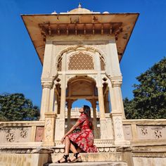 a woman in a red dress sitting on some steps