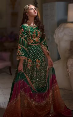 Buy Traditional Mehndi Dress that comes in Green Lehenga Choli beautifully embellished with hand-crafted adornments and embroidery work. Custom Sizes. Green Mehendi Outfits For Bride Pakistani, Bridal Mehndi Dresses Green, Lengha Choli Pakistani Mehndi, Emerald Green Mehndi Outfit, Green And Orange Mehndi Dress, Orange Mehndi Dress Pakistani, Emerald Green Pakistani Dress, Colorful Mehndi Outfit, Mehndi Lehnga Pakistani Lehenga Choli