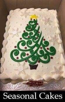 a christmas tree cake in a box with the words seasonal cakes written on it and an image of a cupcake