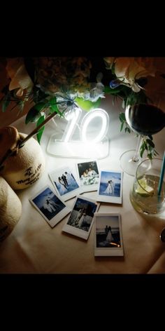 the table is covered with pictures and flowers, including an illuminated number twenty sign on it