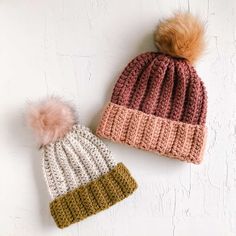 two crocheted hats with pom - poms on them