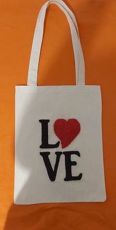 a white bag with the word love embroidered on it