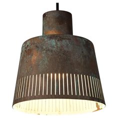 an old rusty light hanging from a ceiling fixture with metal strips on the bottom and sides