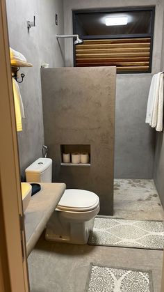 a bathroom with a toilet, sink and towel rack in the middle of the room