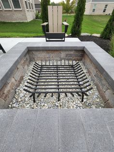 an outdoor fire pit surrounded by rocks and gravel