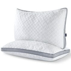 two pillows on top of each other with white and gray trimmings, one in the