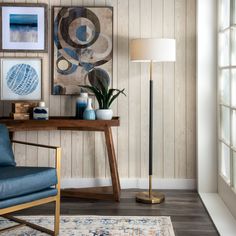 a blue chair sitting in front of a table with a lamp on top of it